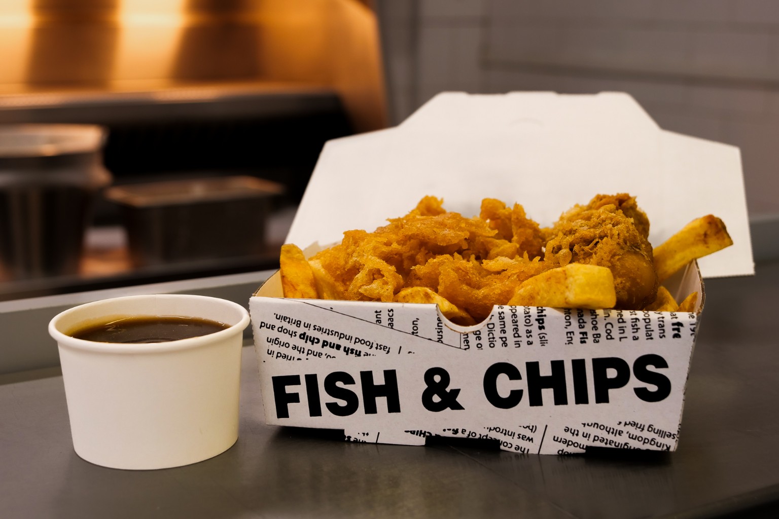 Freshly cooked chips and scraps in a fish and chips box